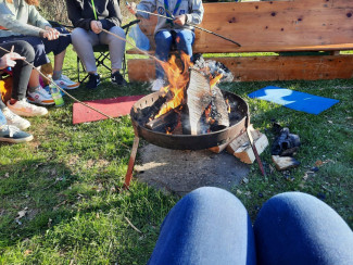 Jugendliche sitzen um eine Feuerschale