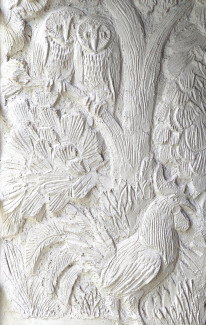 Weißes Steinrelief mit Hahn und Pflanzen