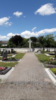 Weg über den Friedhof Mühlhausen mit Kreuz im Hintergrund