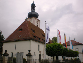 Die Maria-Kilian-Kirche von außen mit Fahnen